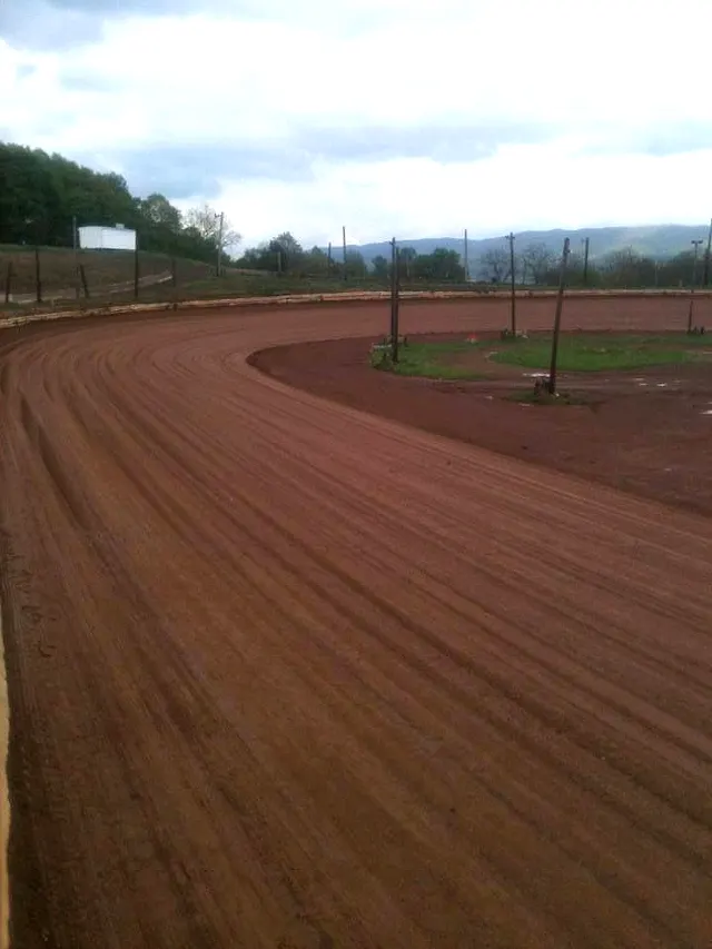 The banked clay turn at Path Valley Speedway with the valley behind